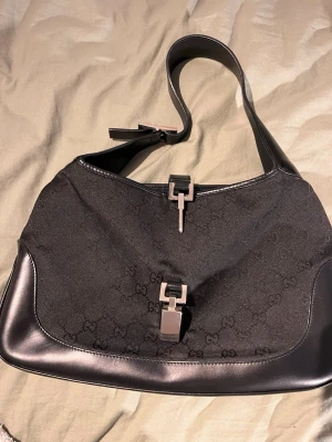 Gucci Jackie - Gucci Jackie väska inköpt i Japan. Inga fläckar eller defekter på tyget, men låsningen saknas till väskan som ni kan se på andra bilden, därav billigare pris. Inköpt för 5000kr~