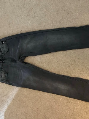 Replay Anbass svarta jeans - Säljer ett par Replay Anbass jeans i grå färg med klassisk femficksdesign och smal passform. Jeansen har Replay-logga på fickan och är tillverkade i mjukt jeansmaterial som sitter snyggt. Perfekta för dig som gillar stilrena och moderna jeans.