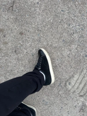 Lanvins cap toe  - Snygga svarta lanvins med vit sula. Skorna har svarta skosnören och metallfärgade öljetter. Ovandelen verkar vara i mocka eller canvas och tån är i blankare material. Perfekta för en clean och stilren look.