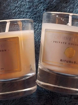 Doftljus i glas från Rituals ( cashmere rose) - Två stilrena doftljus i glas från Rituals Private Collection. Ljusen är vita med en lyxig etikett i guld och beige toner. Perfekta för att skapa en mysig stämning hemma och sprida en behaglig doft i rummet.