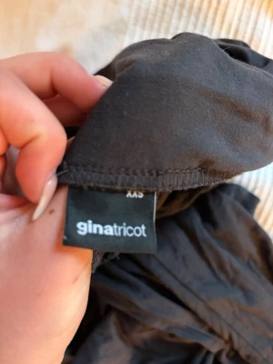 Svart långkjol Gina Tricot - En svart långkjol från Gina Tricot i enkel och rak modell. Kjolen är perfekt för dig som gillar minimalistisk och stilren look. Tillverkad i mjukt material som känns skönt mot huden.