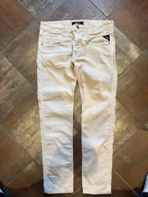  Replay jeans - Snygga beige jeans från Replay med rak passform och klassisk femficksdesign. Jeansen har bälteshällor, knappgylf och diskreta detaljer. Tillverkade i ett mjukt bomullsmaterial som ger en avslappnad look.