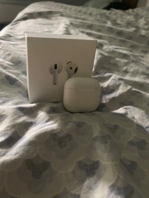 Vita trådlösa hörlurar med laddningsetui - AirPods 4 – 1 AirPod + laddningsetui, laddningskabel & originalbox  Säljer mina AirPods 4. 1 AirPod ingår tillsammans med original laddningsetui, USB-C-laddningskabel och originalbox.  Ingår:  * 1 AirPod * Original laddningsetui * USB-C-laddningskabel * Originalbox  Ingår inte:  * Väggadapter/laddningskloss  Allt fungerar som det ska och är i bra skick med normalt användningsslitage. Se bilder för skick.