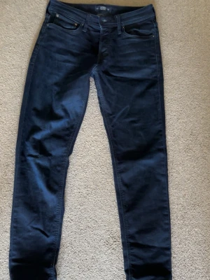 Mörkblå slim fit jeans | Jack & Jones - Snygga mörkblå slim fit jeans med klassisk femficksdesign och smal passform. Jeansen har en enkel look utan slitningar och är tillverkade i ett stretchigt material för extra komfort. Perfekta för dig som gillar en stilren och modern look. St- 30,34