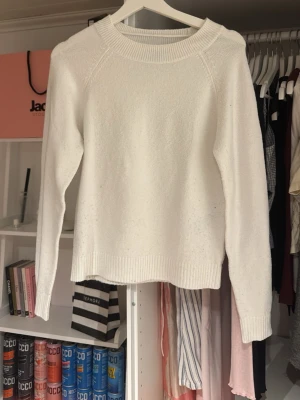Vit stickad tröja från Vero Moda - Klassisk vit stickad tröja från Vero Moda i storlek XS. Tröjan har rund halsringning, långa ärmar och ribbade muddar vid ärmslut och nederkant. Perfekt basplagg till garderoben och enkel att matcha med olika stilar.