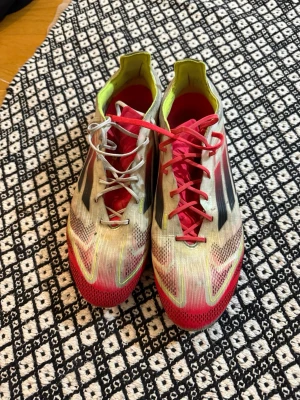 Färgglada fotbollsskor med neon och svart - Säljer ett par väldigt använda adidas F50s elite. Skorna köptes för 3299 och användes i ca ett år. Skorna är i ett använt skick men har fortfarande mycket att ge. De vita snörena är inte original men sitter som originalsnören. Skorna är i storlek 42 2/3 men sitter mer som 41-42.