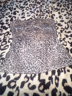 Leopardmönstrad tubtopp - Säljer en snygg leopardmönstrad tubtopp i stretchigt tyg. Toppen är figurnära och har en brun bas med svarta och beige fläckar. Perfekt för dig som vill sticka ut med ett djurmönster. Materialet känns mjukt och har ett tunt innerfoder för extra komfort.