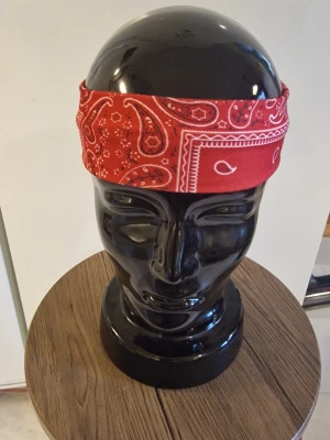 Bandanas/hårband cachewnöt röd - Bandanas/hårband cashewnöt. Elastisk. 23,5 cm huvud. Bredd 6 cm. Trikåtyg. Polyester.