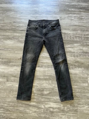 Svarta slim fit jeans med slitningar - Säljer ett par svarta slim fit jeans med snygga slitningar och tvättade detaljer på benen. Klassisk femficksmodell med dragkedjegylf och raka ben. Jeansen har en modern look och passar perfekt till en avslappnad stil.