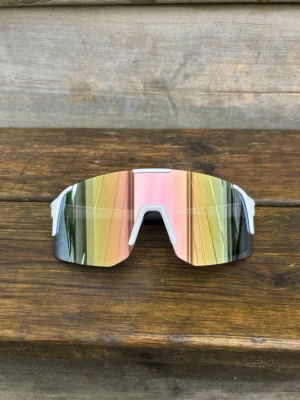 Pastell Rosa Sportiga spegelglasade solglasögon - Bundlerabatt. One size vuxen, unisex Säljer ett par riktigt snygga solglasögon med spegelglas i guld och rosa toner. De har en vit båge och en sportig, futuristisk design som täcker bra runt ögonen. Perfekta för dig som vill sticka ut och samtidigt skydda ögonen mot solen.