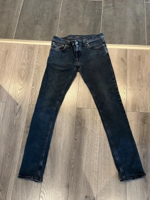 Nudie Jeans Grim Tim  - Säljer ett par riktigt snygga Nudie Jeans i den eftertraktade Grim Tim-modellen. Jeansen har tvär snygg design med mycket karaktär och en unik look som sticker ut. Perfekt tvätt och färg som funkar året runt, oavsett om du vill kla upp eller ner outfiten. Skicka gärna ett meddelande vid intresse eller om du vill ha fler bilder! 