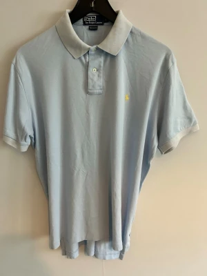 Polo Ralph Lauren piké - • 🇸🇪 Ljusblå Piké från Polo Ralph Lauren. Broderad logga på bröstet.   Använd, men fortfarande i fräscht skick utan några speciella anmärkningar.   Pris går alltid att diskutera vid snabb affär 🥂  
