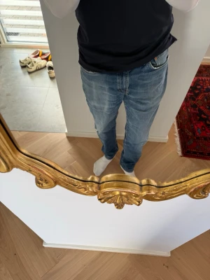 Feta Levi's 512 med sjuk tvätt - Säljer ett par blå Levi's 512 jeans med klassisk femficksdesign och lätt slitna detaljer. Jeansen har en snygg tvätt och är tillverkade i bomull med en skön passform. Perfekta för dig som gillar en modern och avslappnad stil.