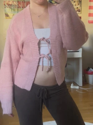 Rosa stickad cardigan med knytband - Söt rosa stickad kofta med två knytband framtill och v-ringning. Superskönt material och i helt nytt skick, oanvänd 💕
