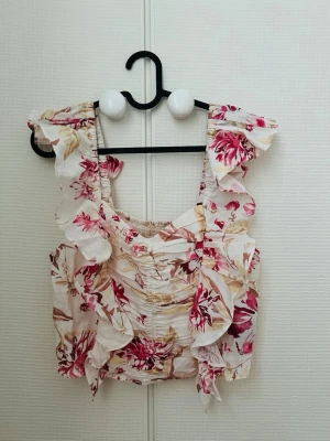 Blommig volangtopp från H&M - Blommig topp med volanger storlek M, helt ny med prislapp kvar. Aldrig använd endast provad. Säljes då den är förstor! Köparen står för frakt ☺️