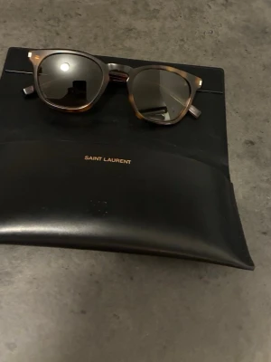 Saint Laurent solglasögon - Snygga solglasögon från Saint Laurent. Kommer med originalfodral i svart. Mycket bra skick. Petfekt inför sommaren ☀️. Skriv. Vid frågor eller funderingar. 