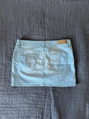Ljusblå jeanskjol från Esprit - Snygg ljusblå jeanskjol från Esprit. Skön passform med låg midja. Perfekt för sommaren och passar till nästan allt.