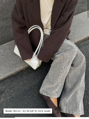 Bruna raka jeans från NAKD - Säljer ett par raka jeans från Nakd med unik textur. Jeansen har en cool, lite ruffig yta och är i Midwaist. Färgen är svår att läsa av men på beskrivningen står de bruna.
