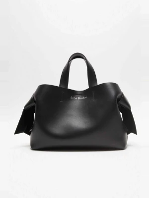 Svart handväska från Acne Studios - Snygg svart handväska från Acne Studios i slätt läder med två topphandtag och coola knutdetaljer på sidorna. Väskan har en stilren och modern design med logotypen diskret framtill. Perfekt för dig som gillar minimalistisk och trendig stil.