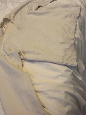 Beige stickad tröja Gina Tricot - Mysig beige stickad tröja från Gina Tricot med bred ribbad kant vid hals, ärmslut och nederkant. Tröjan har en enkel och clean look som passar perfekt till jeans eller kjol. Materialet känns mjukt och bekvämt mot huden.