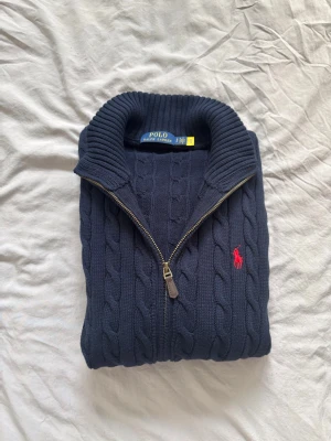 Polo Ralph Lauren Kabelstickad Zip Cardigan - mörkblå/navy - Tjena! Säljer nu denna riktigt feta full zip cardiganen ifrån Ralph lauren. Riktigt rare, ingen som säljer. Färgen är mörkblå, medföljer taggar osv. Ny, använd 1 gång. Vid frågor kontakta gärna! Mvh Adam