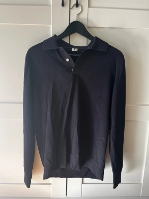 Mörkblå långärmad pikétröja - Snygg mörkblå pikétröja från Arket. Tröjan har använts några enstaka gånger och är i väldigt gott skick. Hör av er om ni har frågor kring någonting!