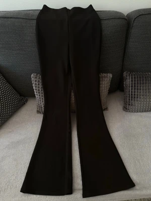Svarta utsvängda byxor - Jätte fina svarta utsvängda byxor i storlek XS & köpta på H&M. 💓 Använts ett fåtal gånger men inga fel på dem. Dem ser samma ut på baksidan. Material, 95% polyester 5% elastan.
