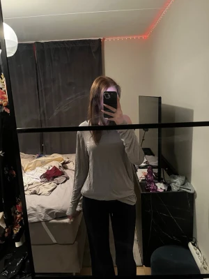 Ljusgrå långärmad topp - Enkel och stilren ljusgrå långärmad topp med lös passform. Toppen har rund halsringning och är tillverkad i ett mjukt material som känns skönt mot huden. Perfekt att matcha med jeans eller kjol för en avslappnad look.