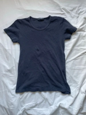 Mörkblå T-Shirt brandy Melville  - Köpte denna T-shirt från brandy Melville för ett år sen. Det finns synliga tecken på slitage, sömmarna längst ner har gått upp, men tyget är inte sönder, finns inget annat slitage. Andvänt flertal gånger. Om intresserad av slitage så fråga.