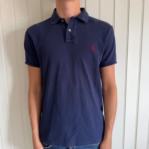 Ralph Lauren Piké - Ralph Lauren Pikétröja (Custom fit) | Size: M | Skick: 8,5/10, igensydda hål i nacken(se bild) Som på sista bilden på båda sidorna(tänks inte på vid användning) annars toppen skick.  | Hör av dig vid frågor och funderingar | Vänliga hälsningar!
