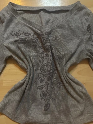 långärmad tröja med blommönster - Snygg långärmad ribbad topp med v ring. Köpt här på plick. Kolla gärna in resten av min profil och se om du hittar något annat du gillar! Kom gärna med egna prisförslag!🤗