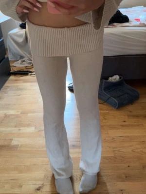Beige stickade leggings - Mysiga beige stickade leggings med ribbad midja och raka ben. Perfekta för dig som gillar en avslappnad och trendig stil. Materialet är mjukt och stretchigt, vilket gör dem superbekväma att bära hela dagen. Liten missfärgning nertill vid ena benet men inget som syns