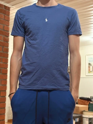 Blå Ralph Lauren T-shirt  - Säljer min blåa Ralph Lauren T-shirt för den är för liten. Änvänd väldigt lite och skicket är som nytt. Hör av er vid funderingar. 