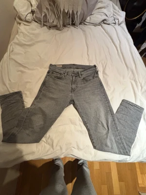 Grå Levi's 511 slim jeans - Snygga grå Levi's 511 slim jeans med klassisk femficksdesign och dragkedjegylf. Jeansen har en modern, smal passform och är tillverkade i mjukt denimtyg. Perfekta för en avslappnad och trendig look.