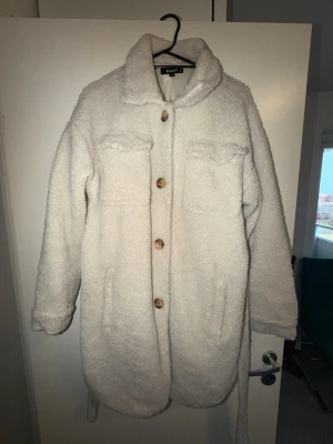 Vit teddyjacka från Missguided - Säljer en fluffig vit teddyjacka från Missguided. klassisk  och mjukt foder. Perfekt för dig som vill ha en mysig och trendig look.