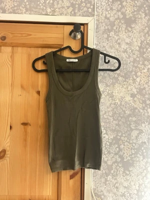 Olivgrön linnetopp från Zara - Olivgrön linnetopp från Zara med breda axelband och rundad halsringning. Mycket bra skick aldrig använd. Hör av vid frågor!💗