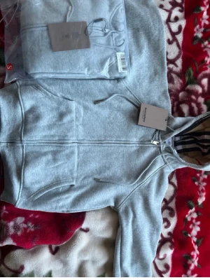 Finns i både S och M  - Snygg grå zip hoodie från Burberry med klassiskt rutigt foder i huvan och dragsko. Hoodien har fickor framtill och en stilren design som passar perfekt till streetwear. Tillverkad i mjuk bomullsblandning för extra komfort.