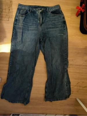 Vida blå jeans från SHEIN 0XL curve grunge goth emo  - Säljer ett par blå jeans från SHEIN i modellen 0XL. Jeansen har en avslappnad, vid passform och klassisk femficksdesign. Materialet är denim och färgen är tvättad blå. Perfekta för en chill och trendig look.