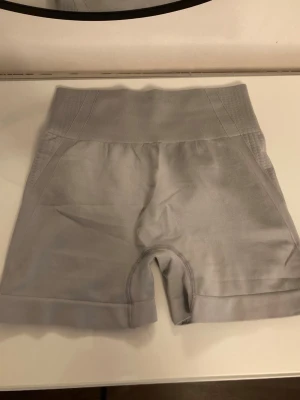 Grå tränings shorts - Grå shorts med sretchigt material som formar kroppen, perfekt för träning. Praktisk scrunch-detalj bak för extra bra passform.  