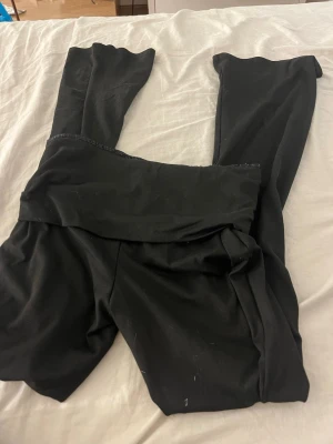 Svarta low waisted yoga pants - Säljer ett par svarta yoga pants med stretchigt material. De har en enkel, stilren design utan synliga loggor eller detaljer. Perfekta för en avslappnad och bekväm look.