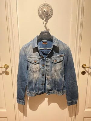 Nudie Jeans  - En sällsynt jeansjacka från Nudie. Passar perfekt nu inför vår och sommar säsongen. Stilren och passar för varje tillfälle. Du kommer vara ensam med denna unika jacka! 🌟Vid frågor eller funderingar är det bara att skicka ett meddelande! 🔔 Mvh  SecondTreasures. 