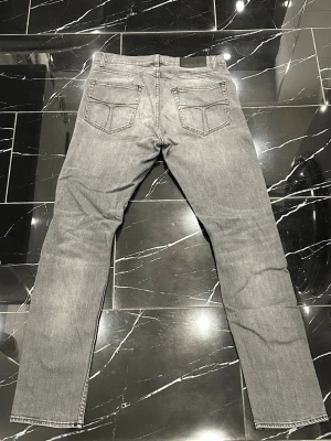 Tiger of Sweden pistolero  - Snygga grå jeans i klassisk femficksmodell med slimmade ben och normal midja. Jeansen har en ljus tvätt och subtila slitningar framtill för en avslappnad look. Tillverkade i bomull med en liten mängd stretch för extra komfort. W30 L34