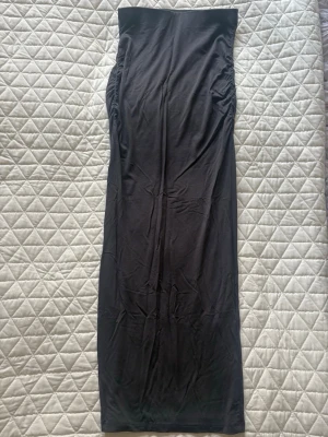 Grå långkjol - Fin tajt långkjol från Gina Tricot. Den är lång och har en enkel, stilren design utan synliga detaljer eller loggor. Perfekta för dig som gillar bekväma och basic plagg till vardagslooken. Aldrig använd