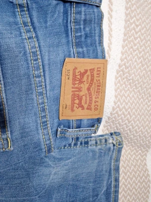 Levi's 512 ljusblå jeans barn - Säljer ett par ljusblå Levi's 512 jeans med klassisk femficksmodell och raka ben. Jeansen har snygga kontrastsömmar och den ikoniska läderlappen bak i midjan. Perfekta för en avslappnad och trendig look passar barn 14 åring.