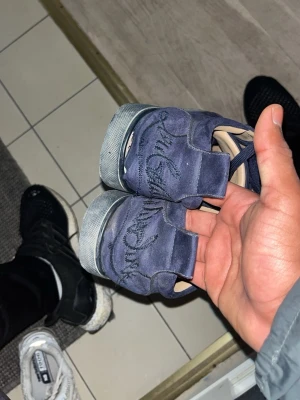 Loubs  - Snygga blåa sneakers från Common Projects i mocka med klassisk låg siluett. Skorna har blå skosnören och en vit innersula i läder. Perfekta för dig som gillar stilrena och exklusiva sneakers med diskret branding på hälen.