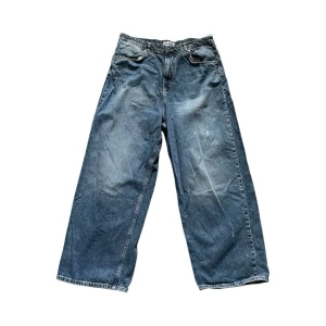 Baggy Jeans - Säljer ett par blåa wide leg jeans med råa kanter nertill (pga användning) och klassisk femficksdesign. Jeansen har en avslappnad passform och är tillverkade i denim. Beställda från Pull & Bear. FYI: Byxorna har lite vit färg på vänster ben, men det ger en liten cool effekt (om man gillar det) Passa på att fråga om bild eller mått om det behövs! ⭐️