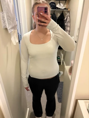 Vit långärmad topp med fyrkantig ringning - Snygg vit långärmad topp från H&M med fyrkantig ringning. Toppen är i mjuk bomull och har en tight passform som sitter snyggt på kroppen. Perfekt att styla med jeans eller kjol för en clean look.