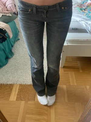 Mörkgrå bootcut jeans - Snygga mörkgrå bootcut jeans med låg midja och klassiska fem fickor. Jeansen har en lätt tvättad look och raka ben som går ut lite nertill. Perfekta för en avslappnad och trendig stil.