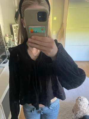 Svart blus med volangdetaljer - Svart blus från Gina Tricot med v-ringning. Storlek 158/164. Säljer då den tyvärr börjar bli för liten.