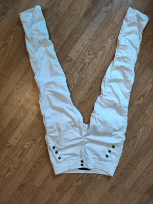 Vita jeans byxor från Freequent dam stl M - Säljer ett par supersnygga vita jeans med dekorativa knappar framtill. Jeansen har två fickor bak och smal passform hela vägen ner.. Perfekta för dig som gillar en clean och modern stil. Har jättefin och smickrande passform på. Märke: Frequent. Dam stl M. Bra skick. Rökfritt hem men katthår kan förekomma.